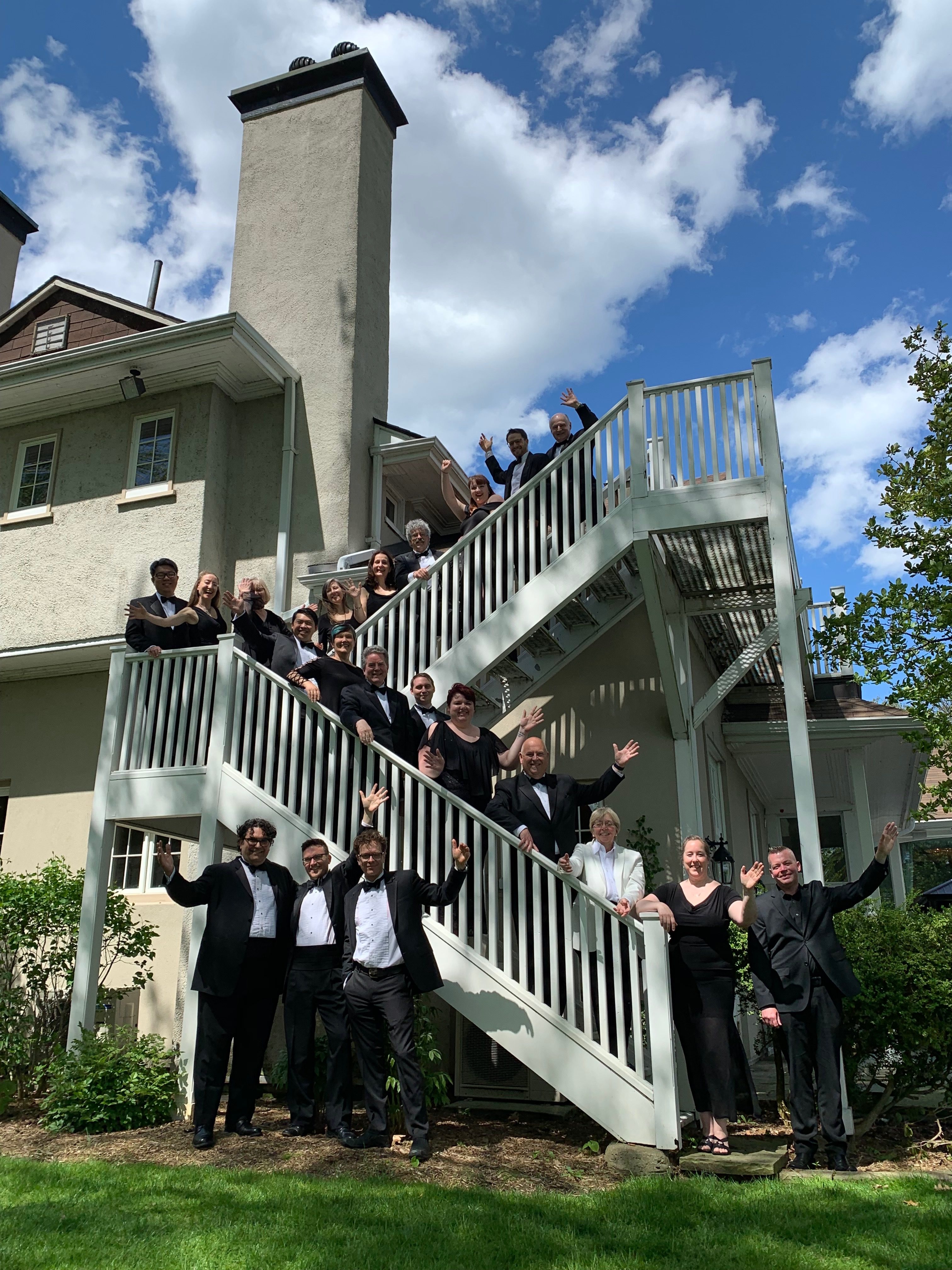 Elmer Iseler Singers waving on a staircase at the Toronto Hunt Club